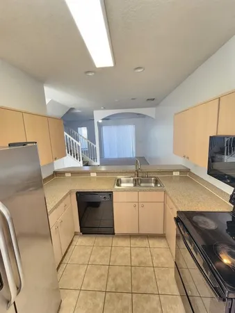 a kitchen with a sink a stove top oven and cabinets