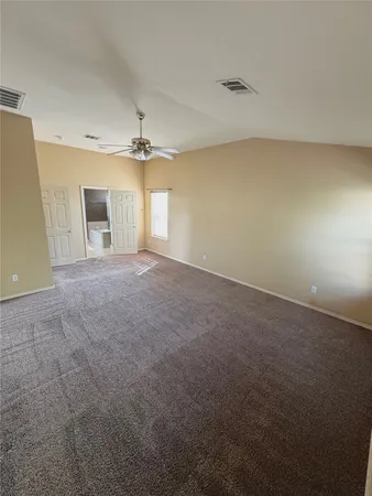 an empty room with windows and ceiling fan