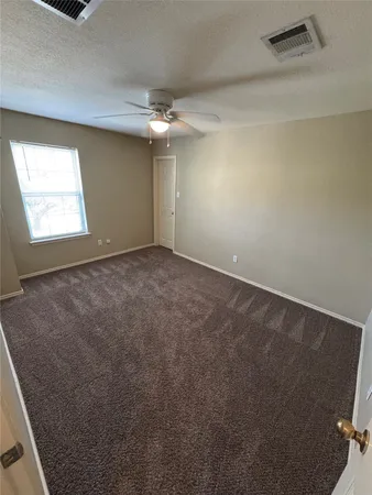 en empty room with windows and fan