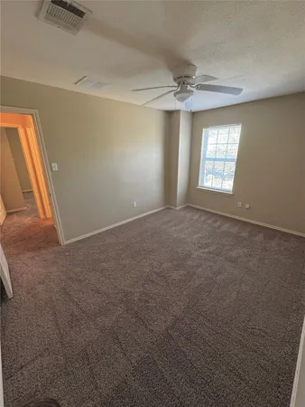 an empty room with windows and fan