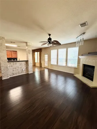 an empty room with wooden floor a fireplace and windows
