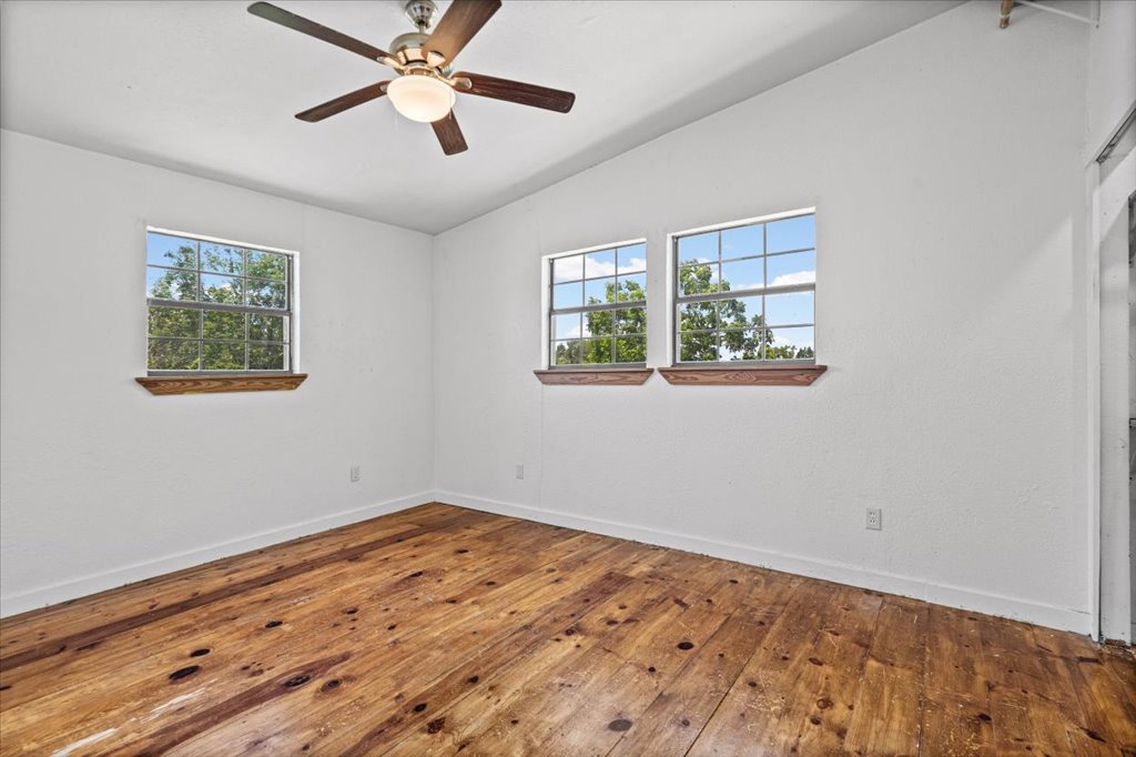 555 Harmon Hills Road, Unit A Dripping Springs, TX 78620 - Photo 25 of 29 Well-lit interior space with natural light and rich wooden floors.