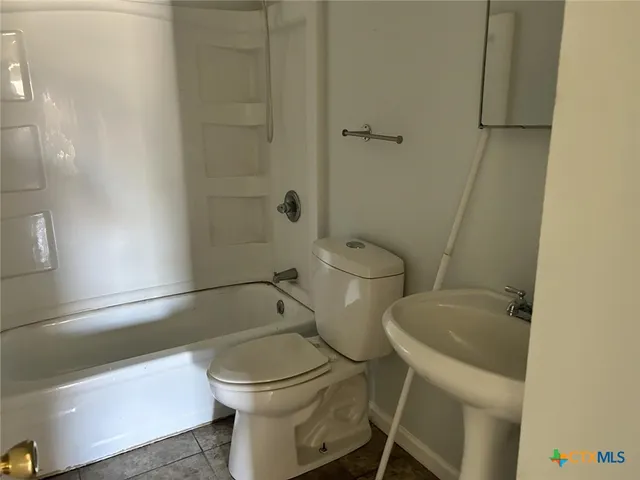 a white toilet sitting next to a bath tub