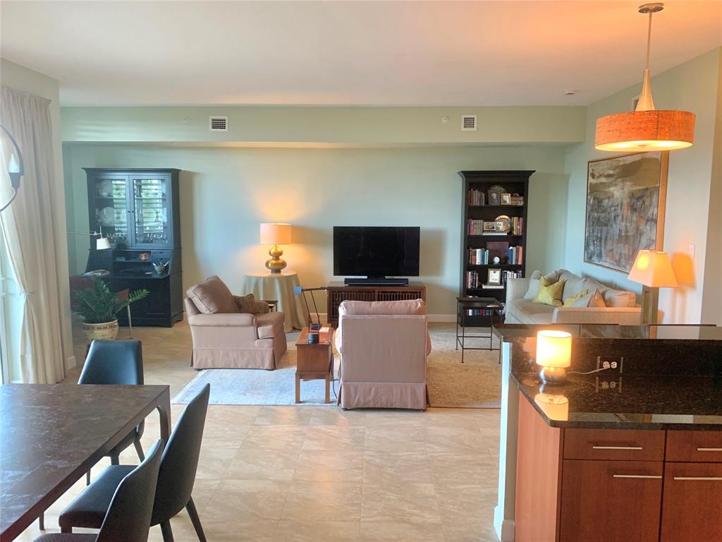a living room with furniture a flat screen tv and kitchen view