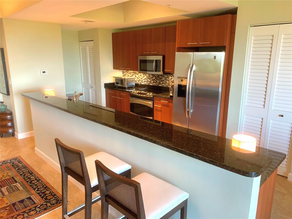2301 Wilton Drive, Unit R409 Wilton Manors, FL 33305 - Photo 11 of 38 a kitchen with stainless steel appliances granite countertop a sink and a refrigerator