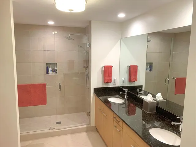 a bathroom with a granite countertop sink a toilet and shower