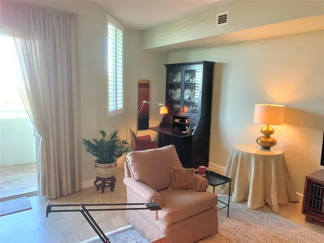 a living room with furniture flowerpot and wooden floor