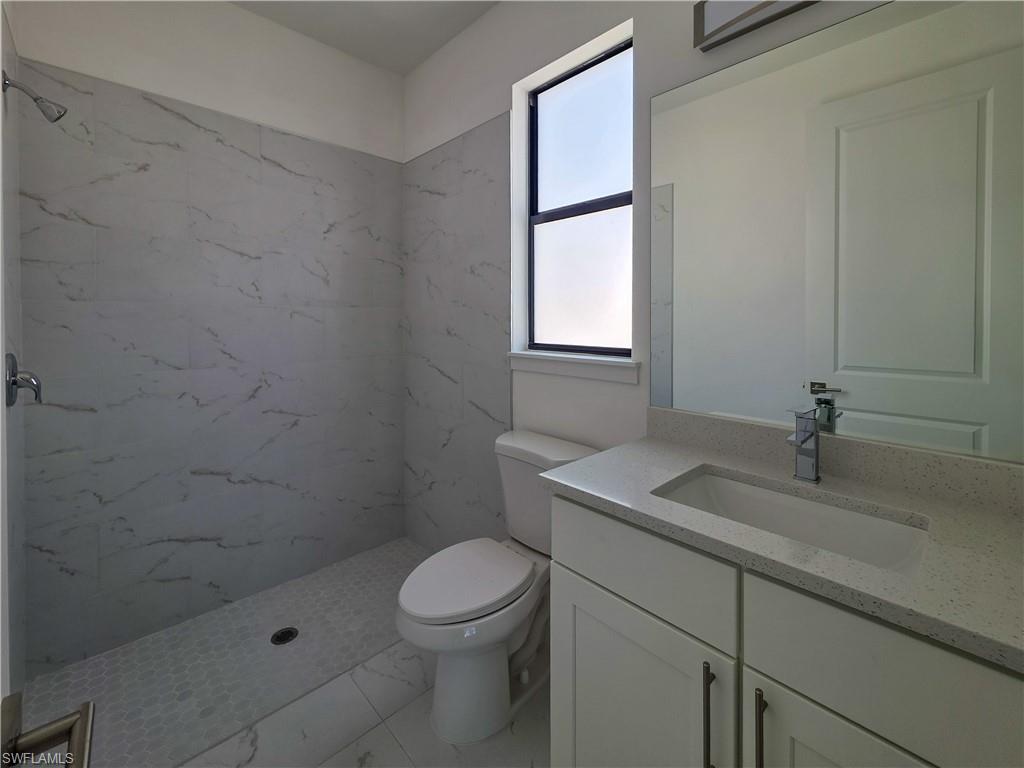 4814 30th Street Southwest Lehigh Acres, FL 33973 - Photo 7 of 11 a bathroom with a granite countertop sink a toilet and shower