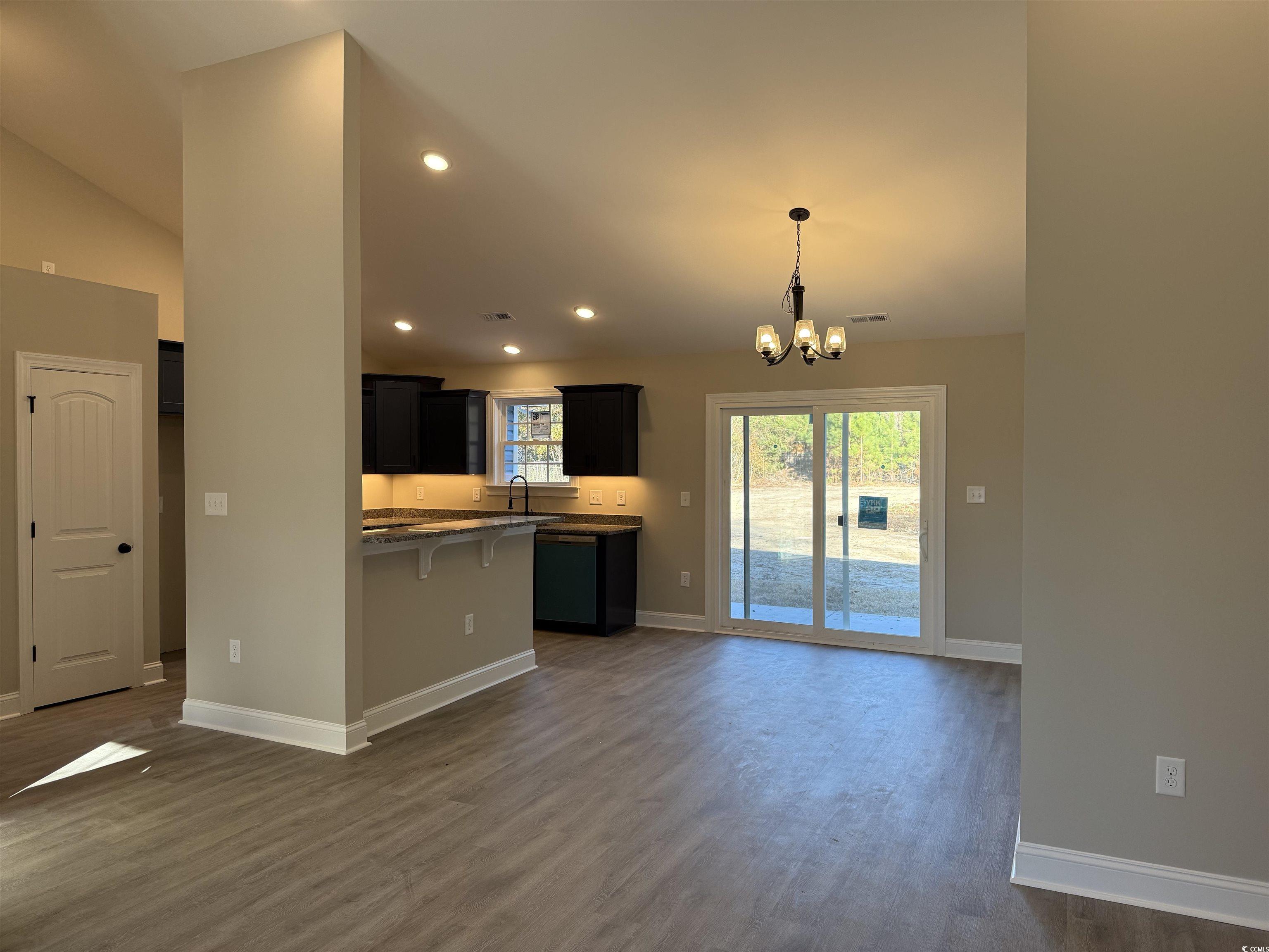 242 Country Club Road Marion, SC 29571 - Photo 13 of 33 Kitchen featuring a chandelier, dark cabinets, a breakfast bar area, decorative light fixtures, and dark wood finished floors
