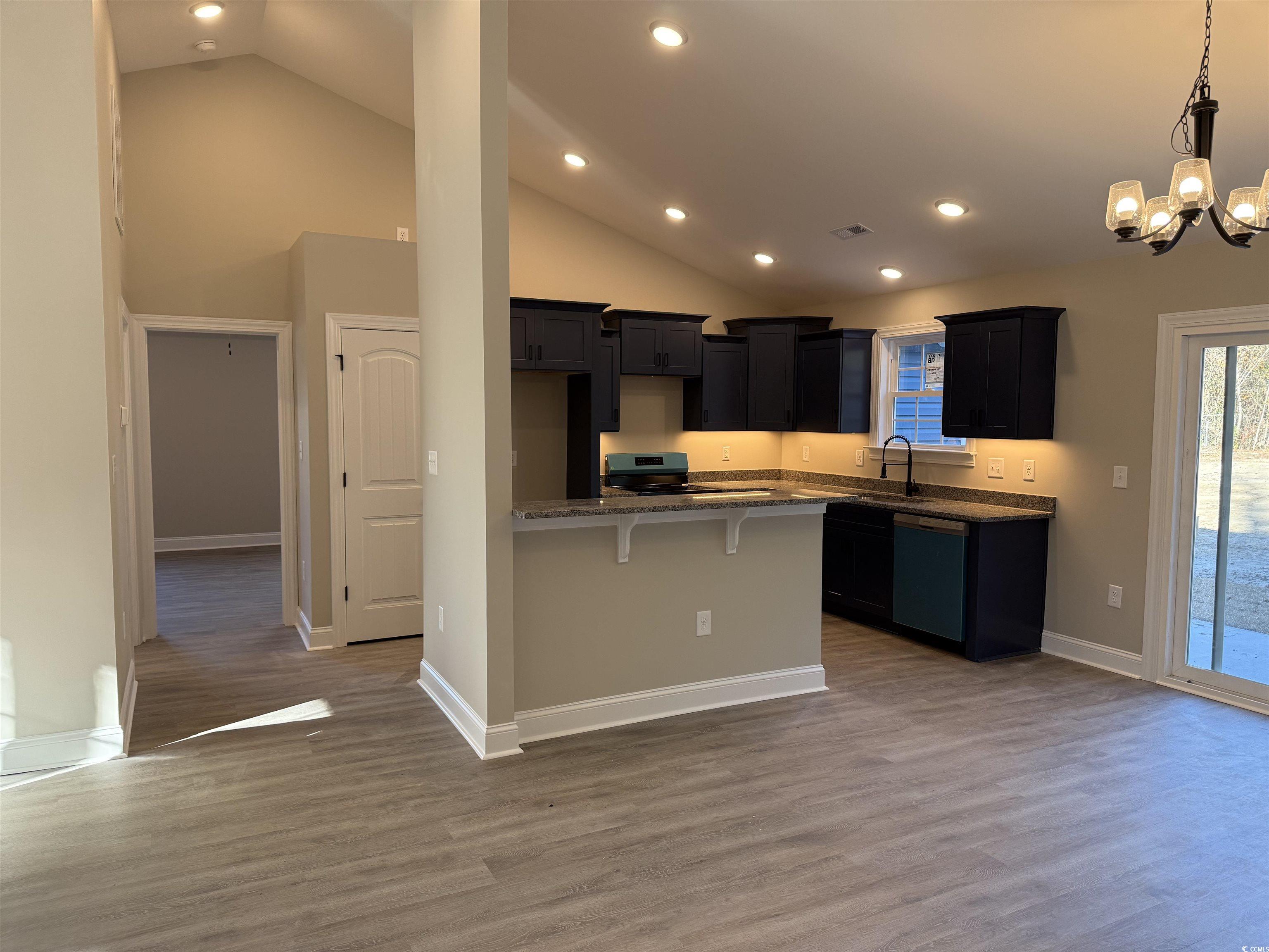 242 Country Club Road Marion, SC 29571 - Photo 14 of 33 Kitchen with a breakfast bar area, dark stone counters, dark wood finished floors, dishwasher, and black range