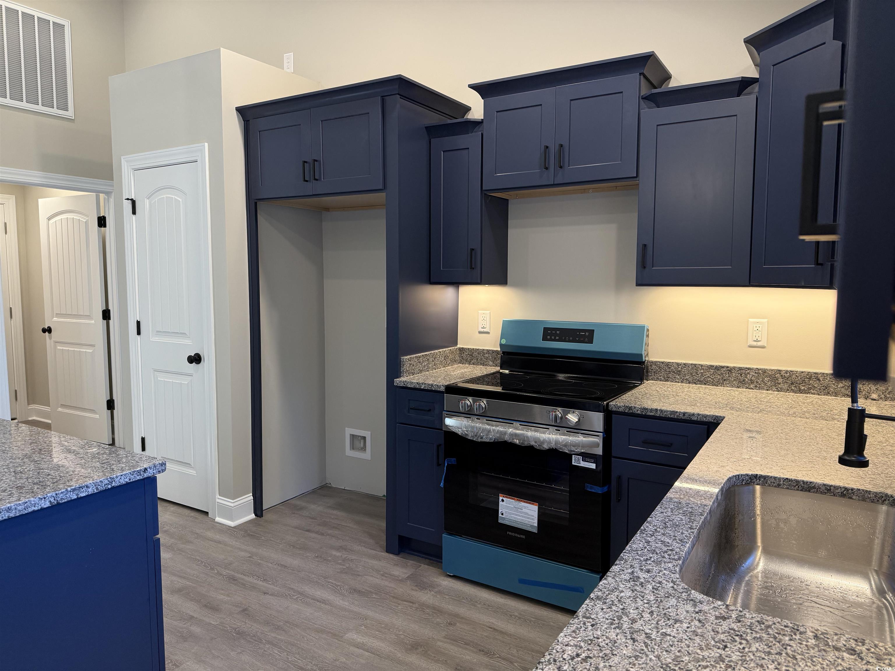 242 Country Club Road Marion, SC 29571 - Photo 17 of 33 Kitchen with electric stove, light stone counters, light wood finished floors, and blue cabinetry