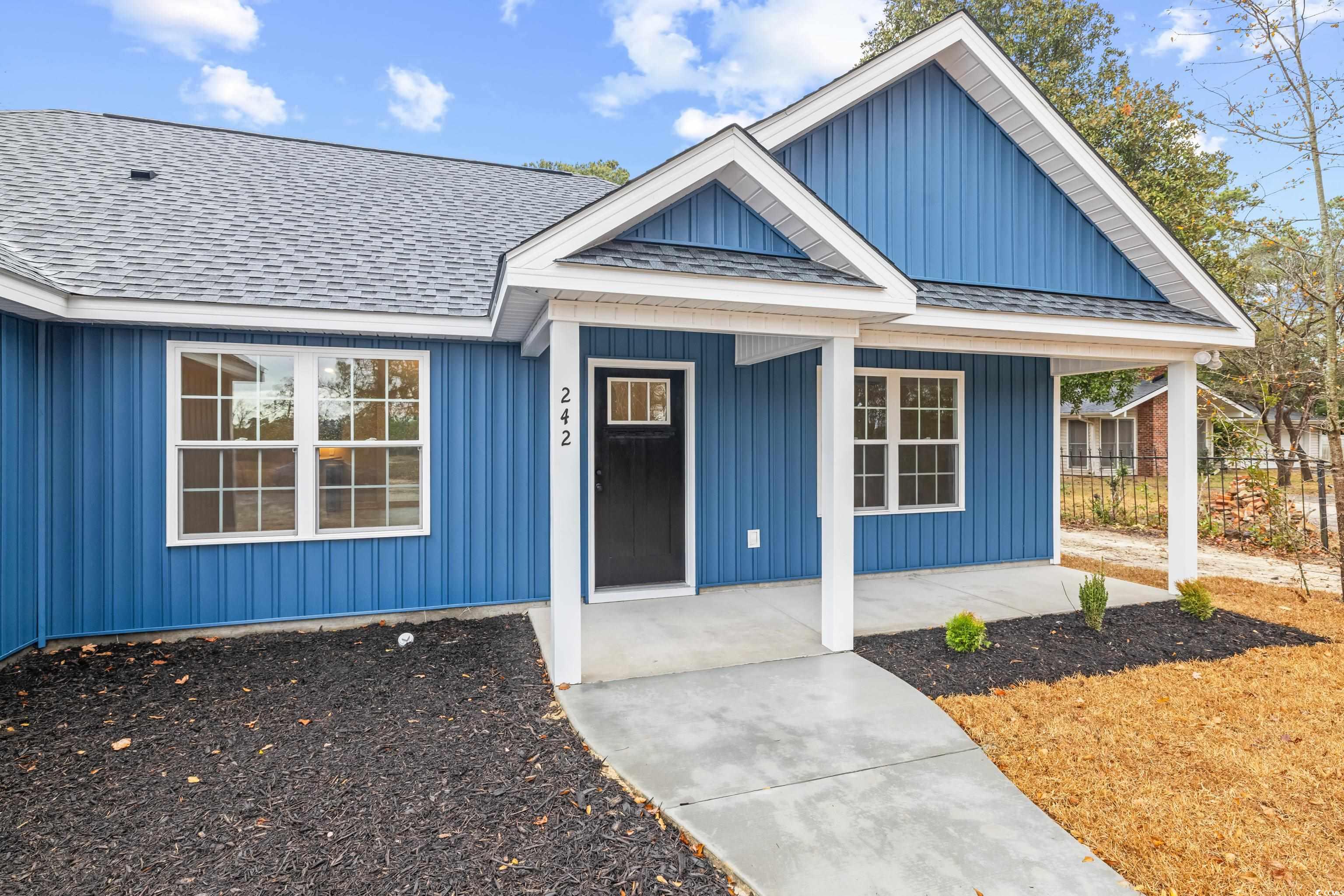 242 Country Club Road Marion, SC 29571 - Photo 2 of 40 View of front facade with a porch, roof with shingles, and board and batten siding