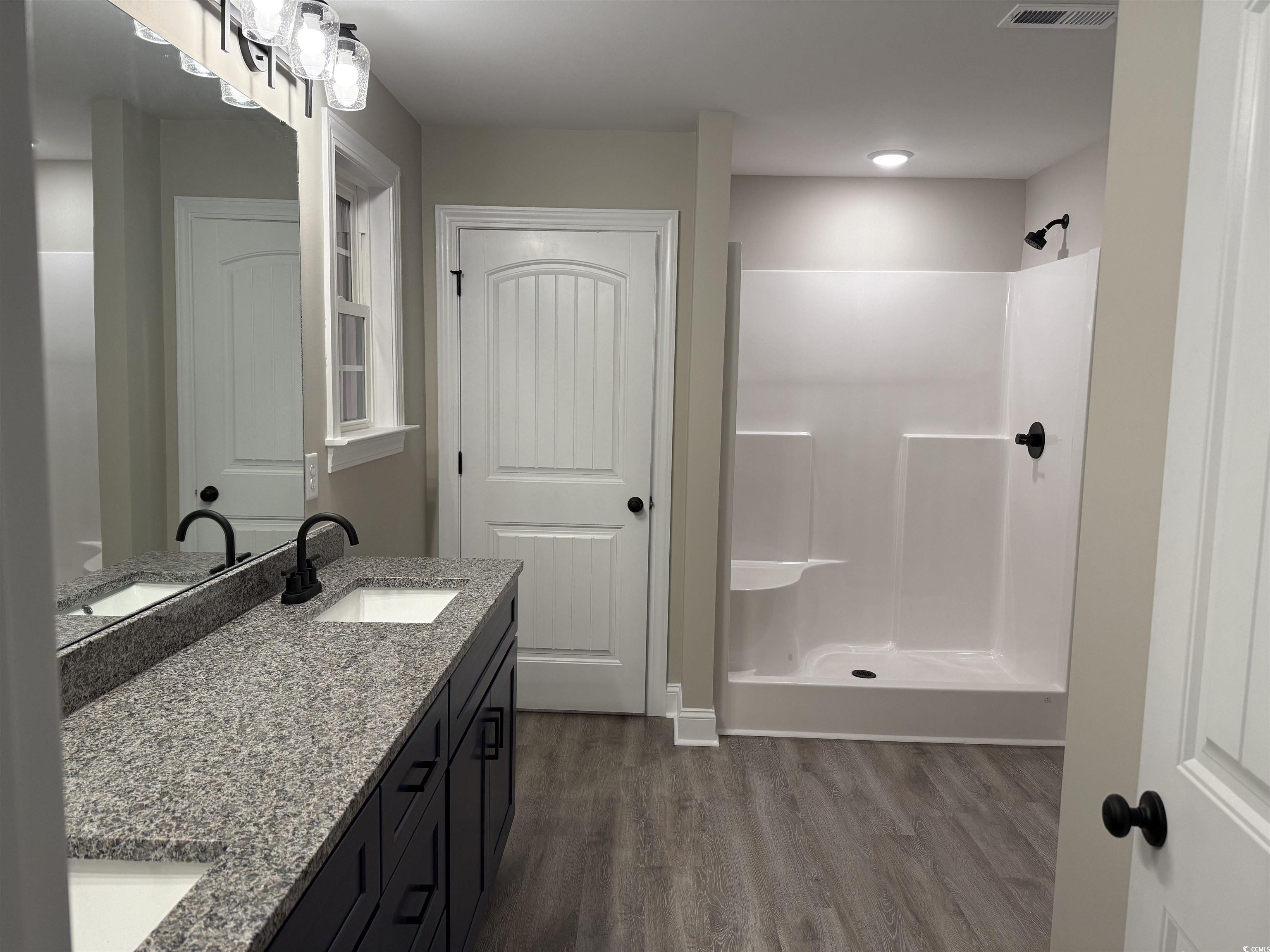 242 Country Club Road Marion, SC 29571 - Photo 23 of 33 Full bathroom with double vanity, a stall shower, and dark wood-style floors