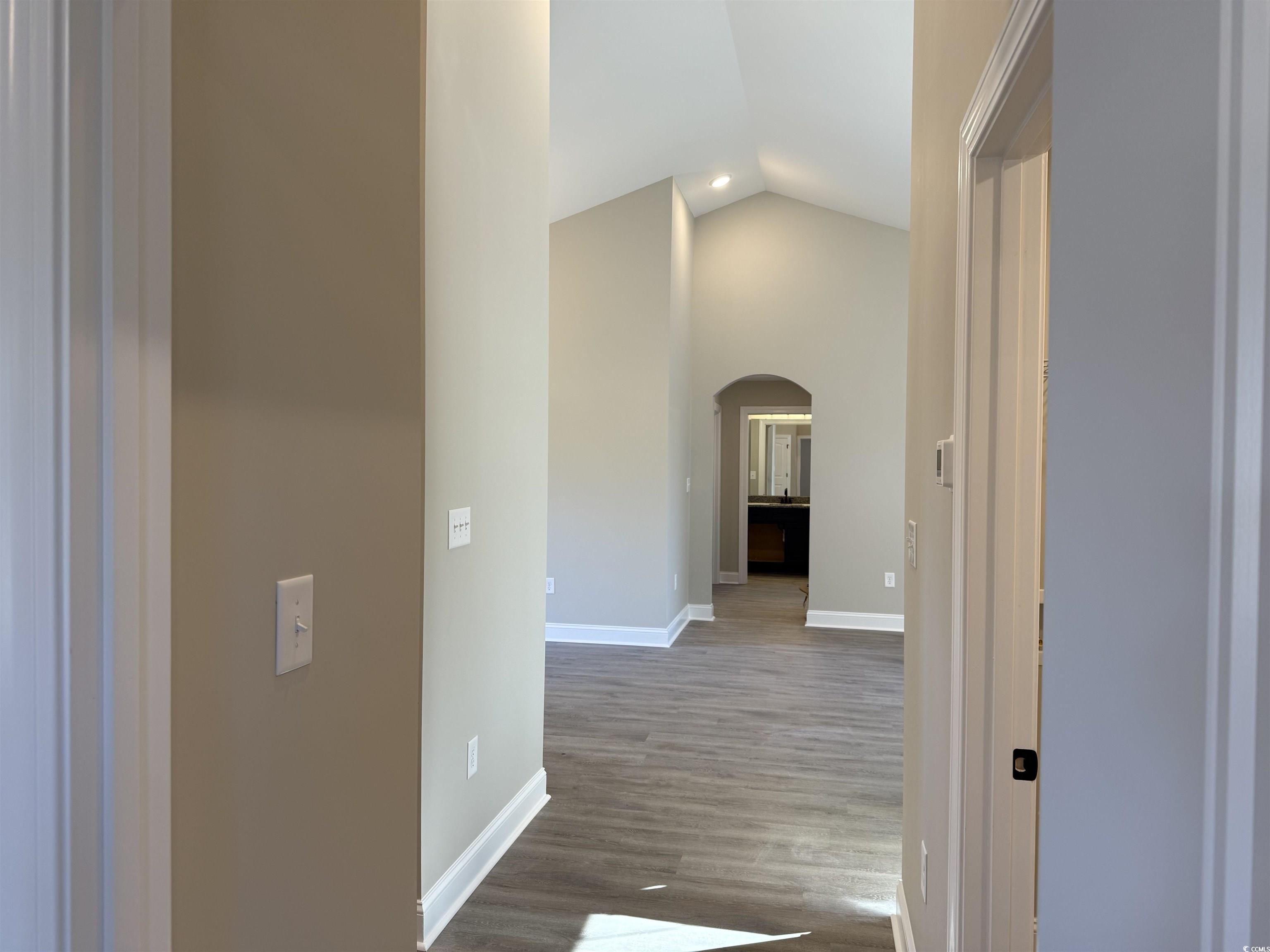 242 Country Club Road Marion, SC 29571 - Photo 26 of 33 Hallway featuring arched walkways, lofted ceiling, and light wood-style floors
