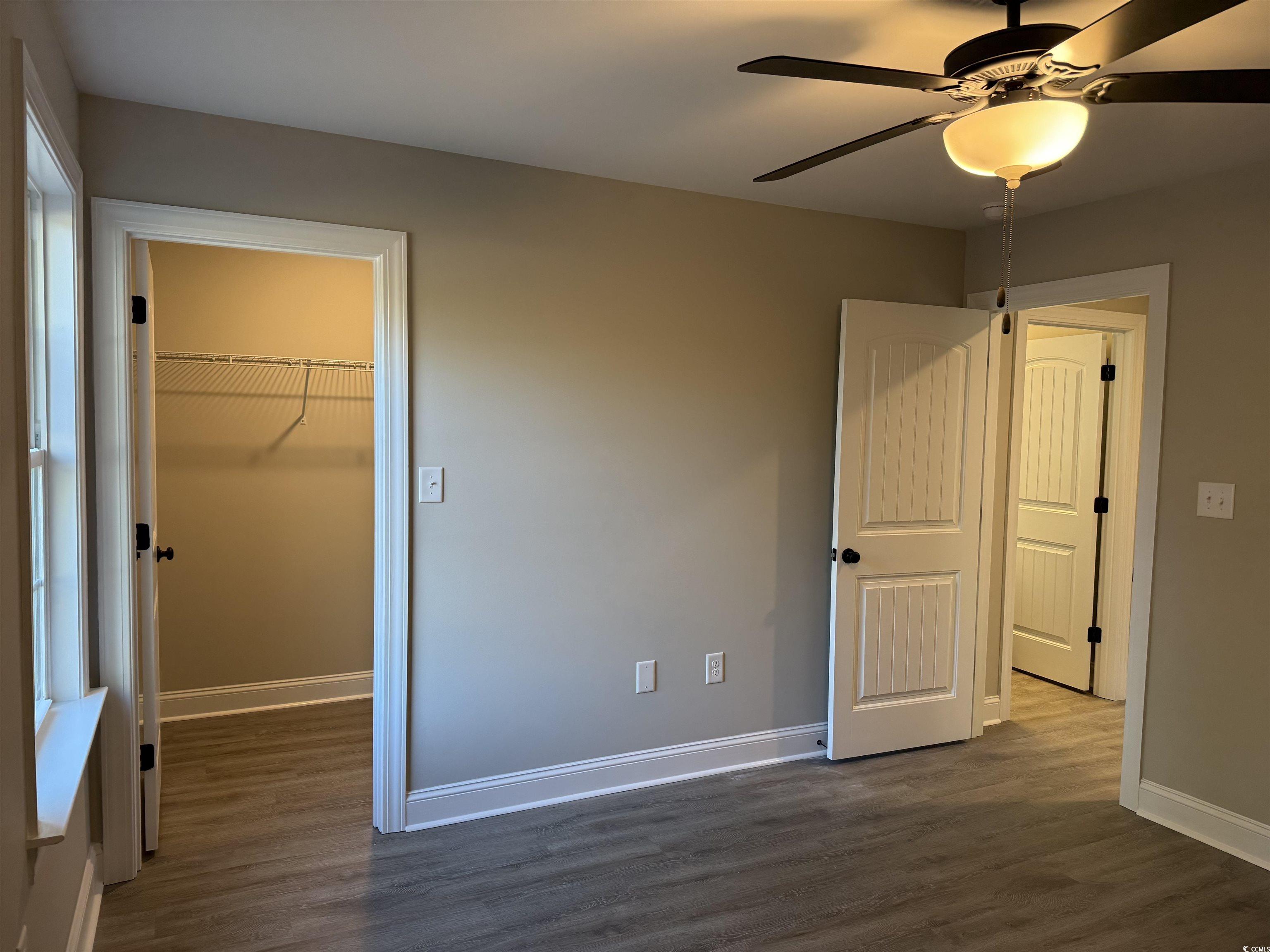 242 Country Club Road Marion, SC 29571 - Photo 27 of 33 Unfurnished bedroom featuring dark wood-style flooring, a spacious closet, and a ceiling fan