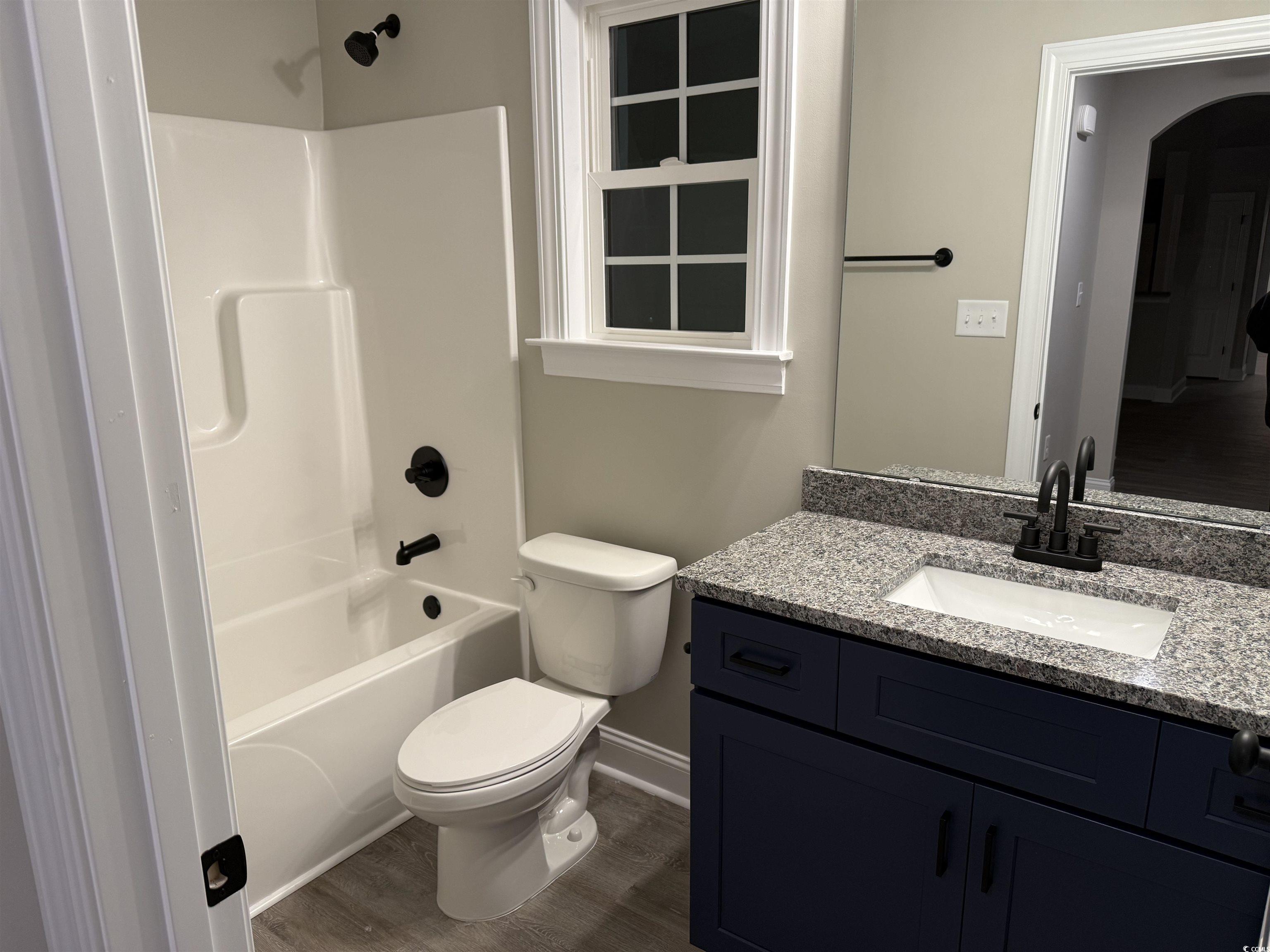 242 Country Club Road Marion, SC 29571 - Photo 29 of 33 Full bathroom featuring bathing tub / shower combination, vanity, and dark wood-style flooring