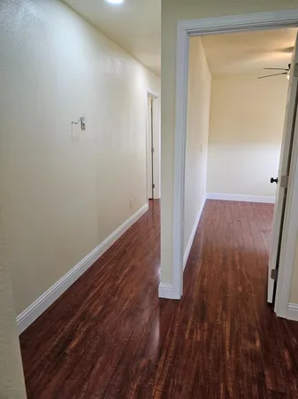 a view of an empty room with wooden floor