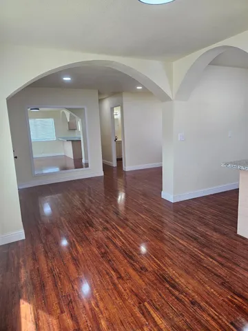 a view of an empty room with wooden floor