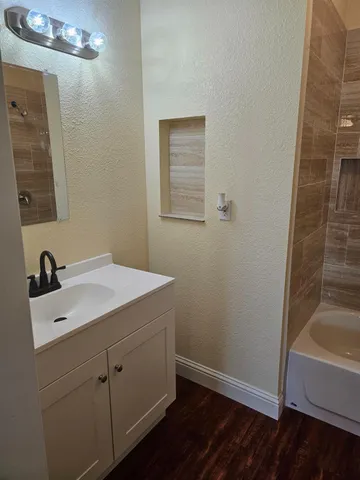 a view of a room with wooden floor and a ceiling fan