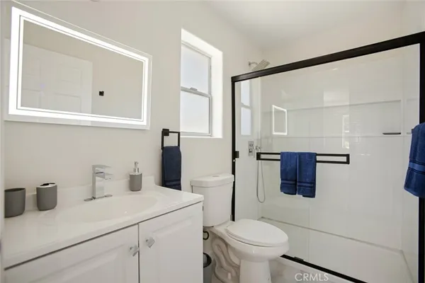 a bathroom with a sink toilet vanity and shower