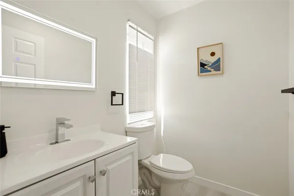 a bathroom with a sink a toilet and mirror
