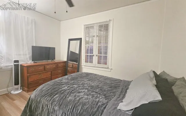 a bed sitting in a bedroom next to a window with wooden floor