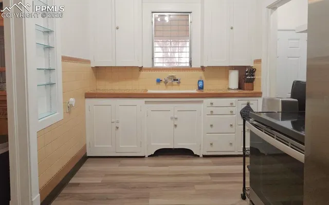 a kitchen with granite countertop white cabinets and sink