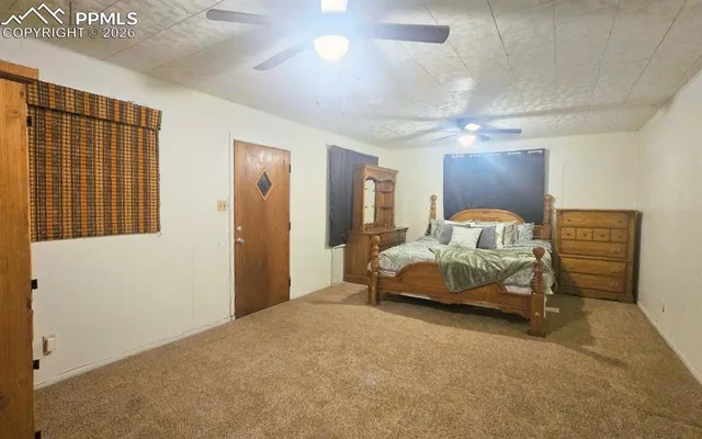 a bedroom with a bed and a ceiling fan