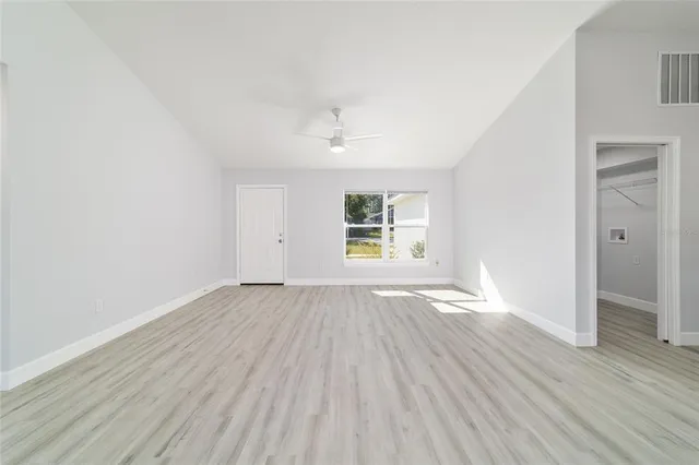 a large white kitchen with kitchen island a stove a sink dishwasher and a refrigerator with wooden floor