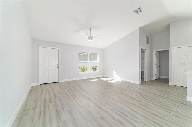 a large kitchen with a center island wooden floor stainless steel appliances and cabinets