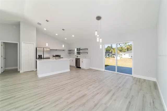 a kitchen with a sink a counter top space stainless steel appliances and cabinets