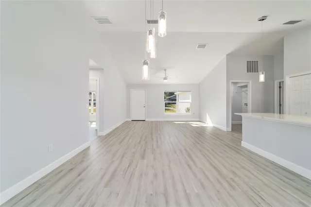 an empty room with a window and wooden floor