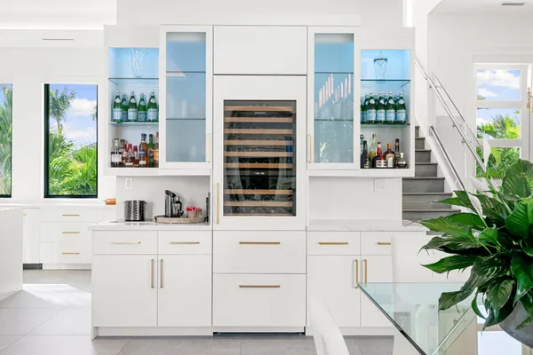 a living room with furniture kitchen view and a large window