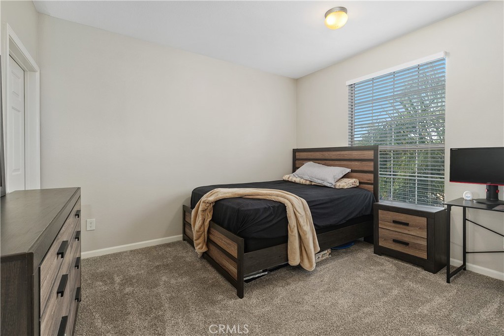 375 Central Avenue, Unit 78 Riverside, CA 92507 - Photo 17 of 43 a bedroom with a bed and a flat tv screen on a dresser