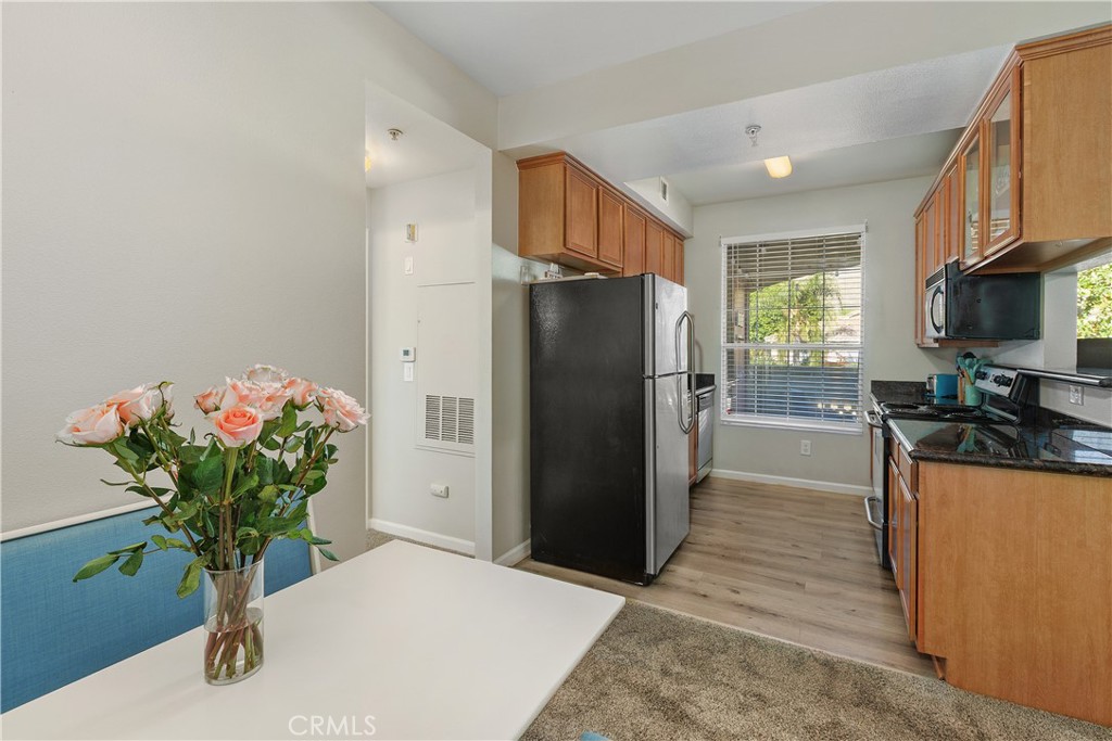375 Central Avenue, Unit 78 Riverside, CA 92507 - Photo 43 of 43 a kitchen with stainless steel appliances kitchen island granite countertop a refrigerator a stove a sink with wooden cabinets and floor