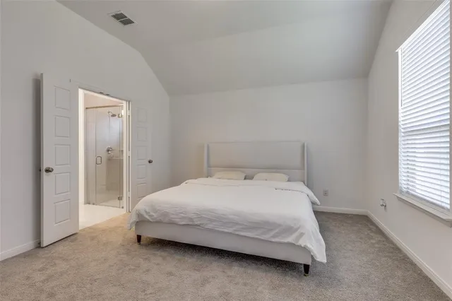 a spacious bedroom with a bed and a window