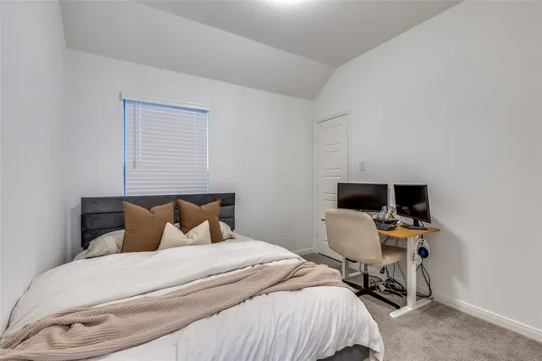 a bedroom with a bed and a computer on a desk