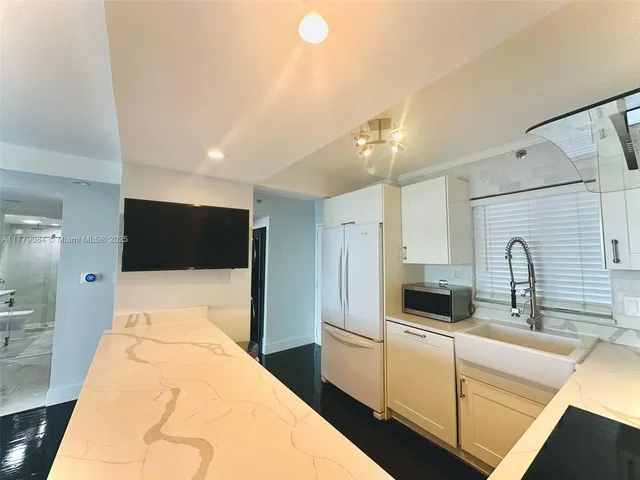 a large white room with a large bed and tv