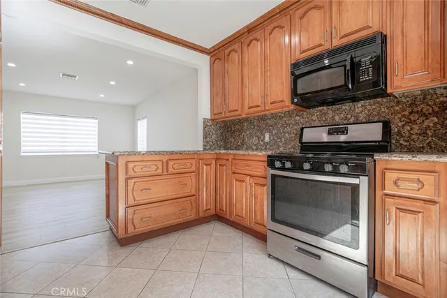 a kitchen with granite countertop a stove microwave and cabinets