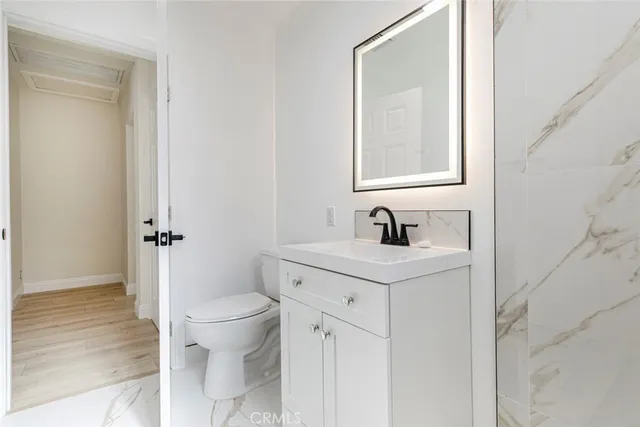 a view of bathroom with a sink toilet and a mirror