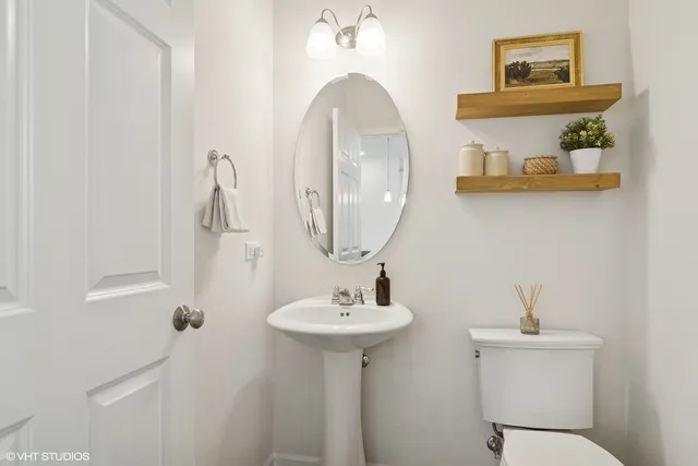 a bathroom with a toilet a sink and mirror