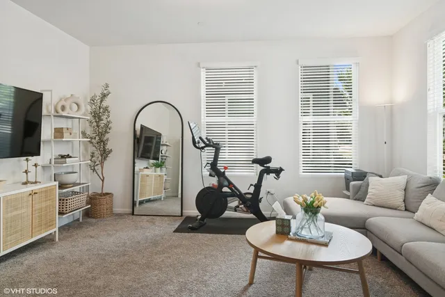 a living room with furniture a flat screen tv and a large window