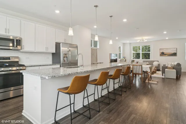a large kitchen with lots of counter space a sink and chairs