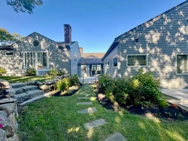 a front view of a house with a garden and plants
