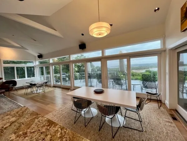 a view of a dining room with furniture large windows and wooden floor