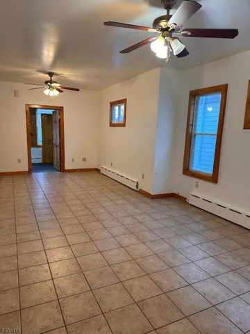 a view of a livingroom with a chandelier fan and windows