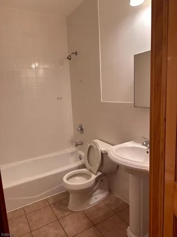 a white toilet sitting next to a bath tub