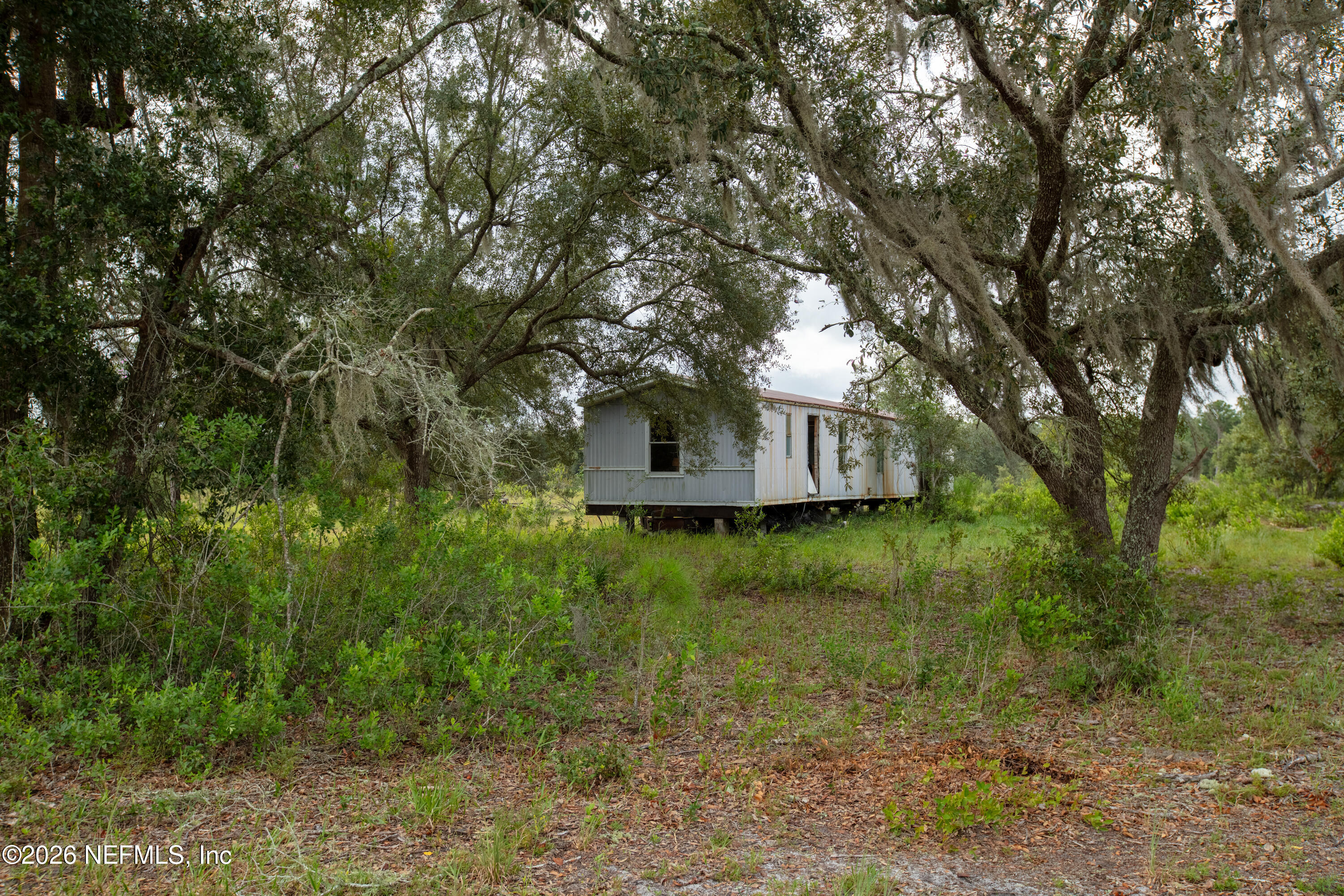 7670 Bundy Lake Road Keystone Heights, FL 32656 - Photo 9 of 22 a backyard of a house with table and chairs
