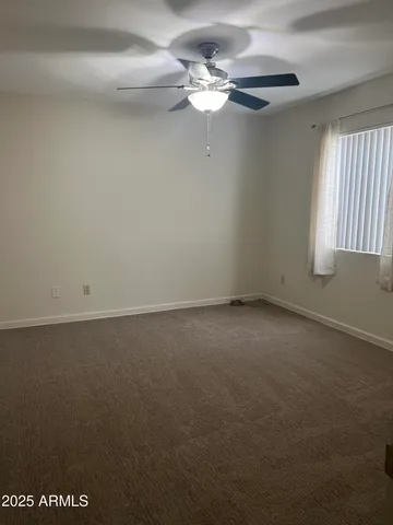 an empty room with a window and a fan