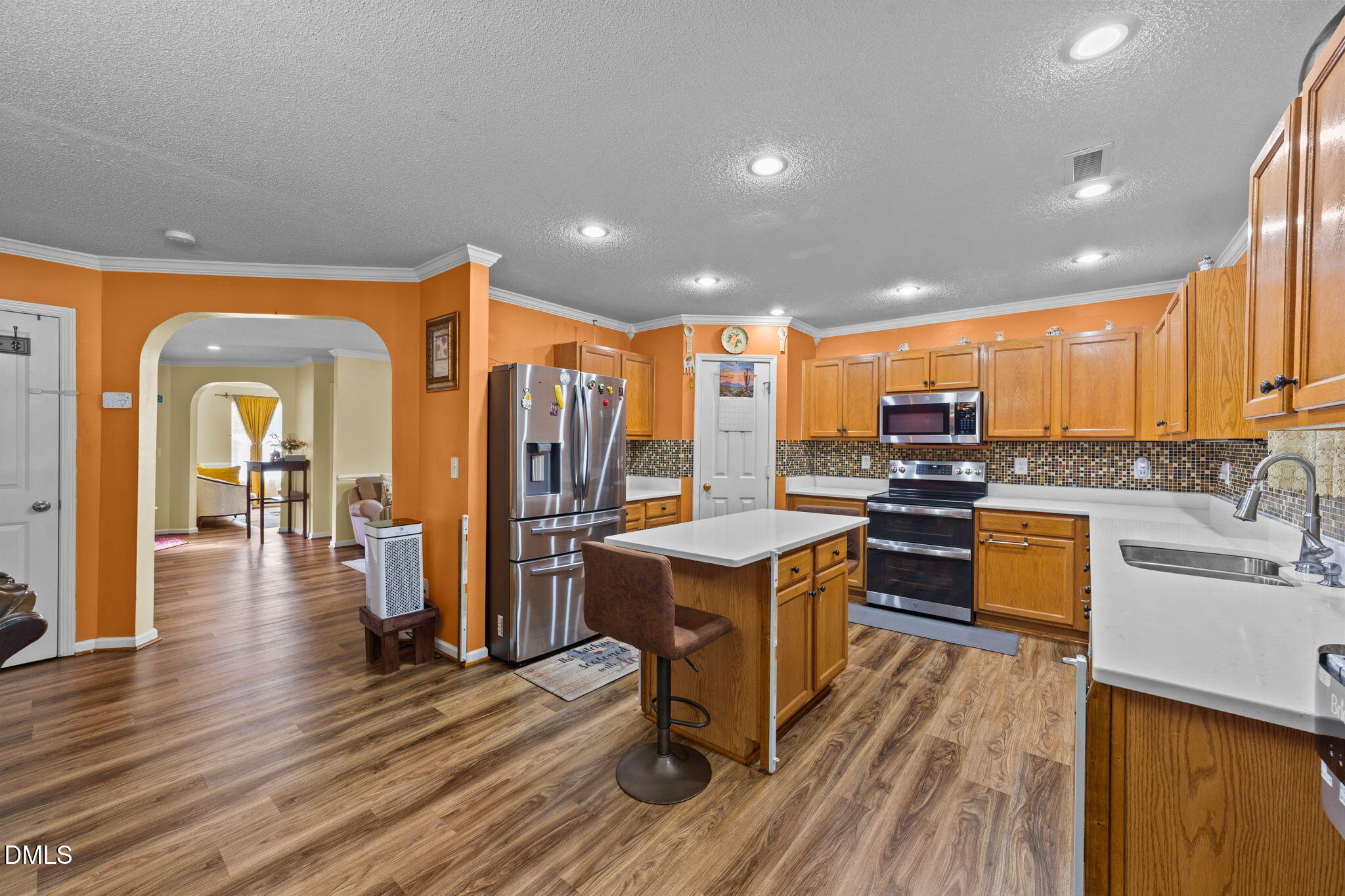 135 Oakton Ridge Place Garner, NC 27529 - Photo 10 of 40 a kitchen with stainless steel appliances kitchen island granite countertop wooden floors and a view of living room